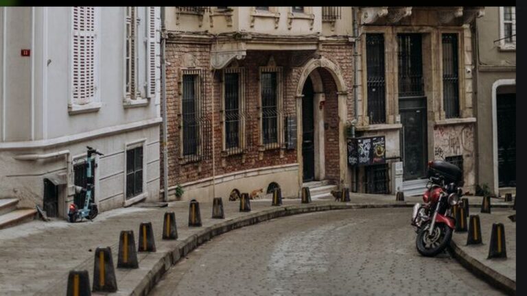 A cobbled street with old terrance houses either side winds to the right and disappears