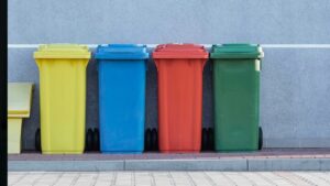A row of four, multicoloured refuse bins