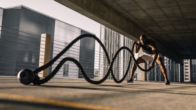 An athlete working with a snaking rope in a modernistic building