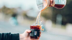 water being poured from a jug into a jar that is already overflowing