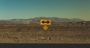 a direction sign pointing both left and right, in a desert