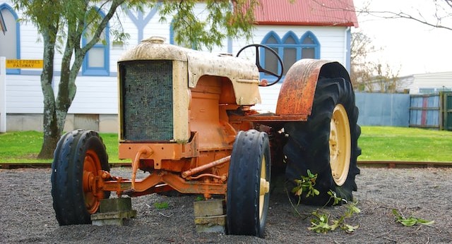 a tractor parked in front of what appears to be a white-walled chapel
