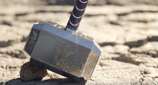the head of a large hammer resting on the ground