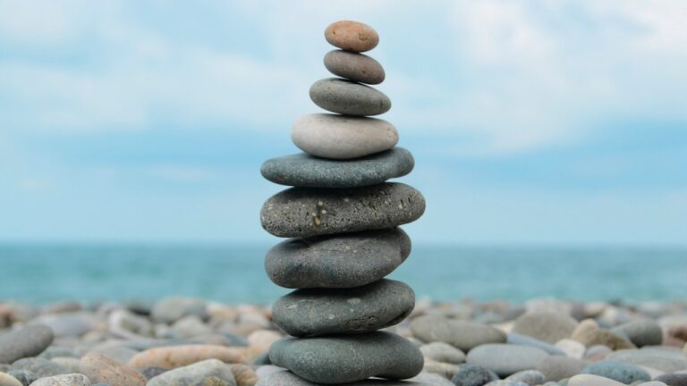 a tower of smooth flat pebbles, on a pebble beach