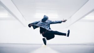 a silhouette of a dancer, mid air, kicking one leg out and with arms outstretched